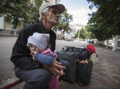 Viktor, 68, hold his 11-month-old granddaughter Alissa as they wait for a bus to leave the eastern Ukranian city of Slaviansk June 17, 2014. Residents flee Slaviansk, the pro-Russian separatist stronghold, what faced with ongoing shortages, utility outages and frequent artillery fire. Ukraine's president said on Monday he had ordered troops to regain control of the frontier with Russia to pave the way for a truce and peace talks after weeks of fighting with pro-Russian separatists. REUTERS/Shamil Zhumatov (UKRAINE - Tags: CIVIL UNREST POLITICS TPX IMAGES OF THE DAY)